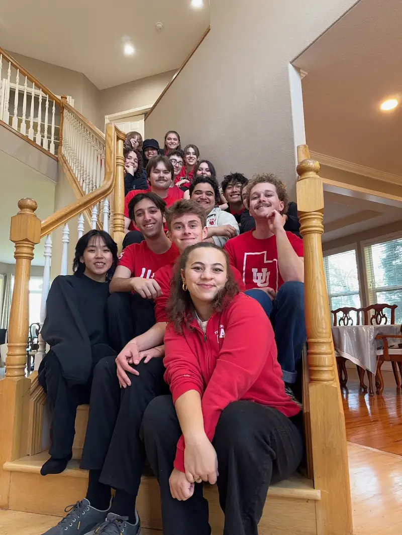 Salt Flats members in red University of Utah shirts on a staircase at retreat